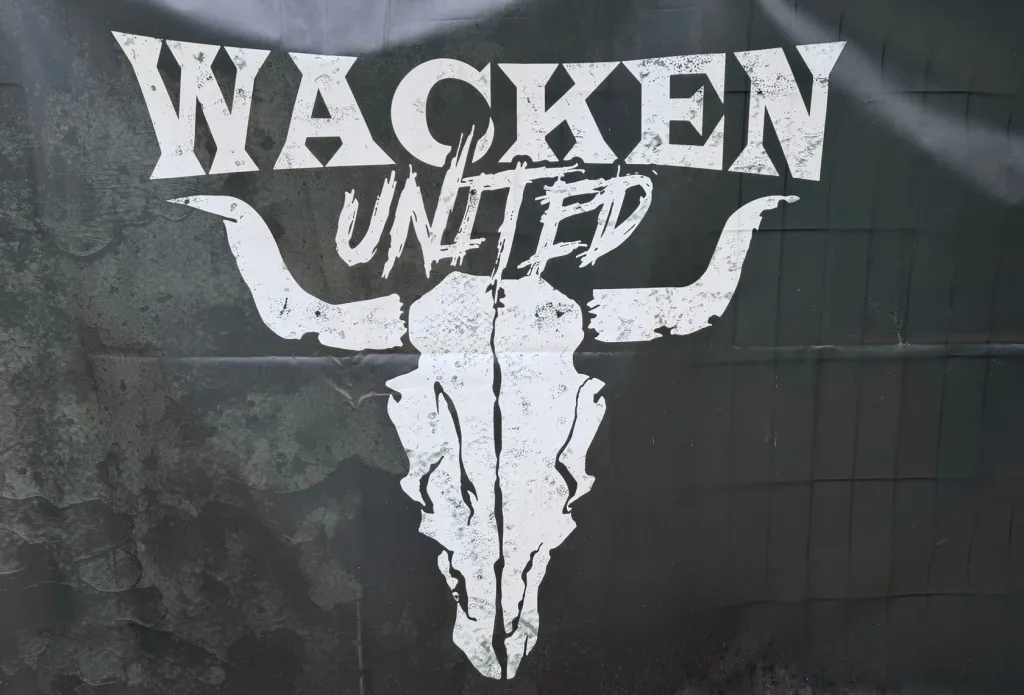 Ein großes schwarzes Banner mit dem Schriftzug „Wacken United“ und dem Stierschädel.